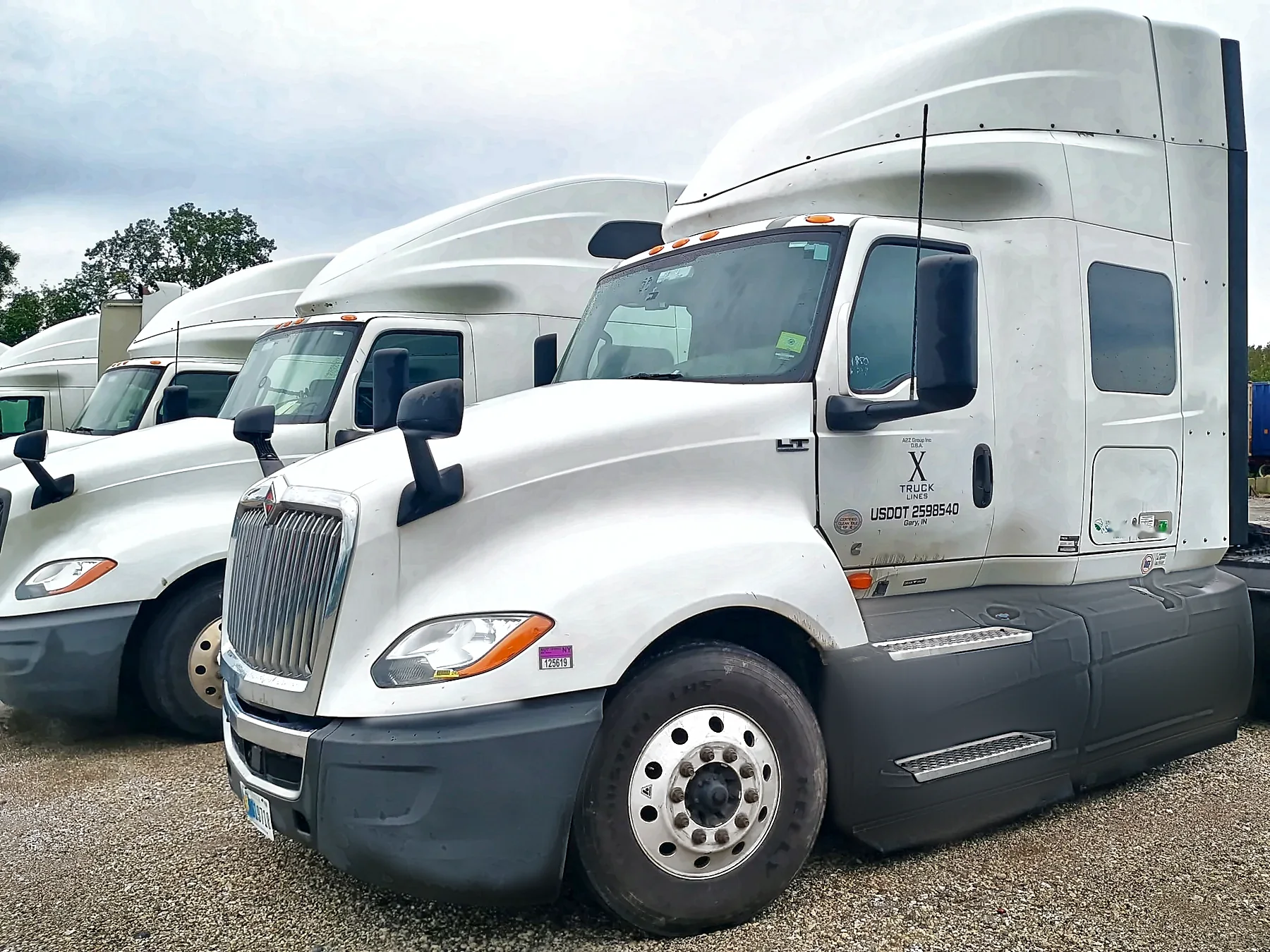Row of white International LT tractors parked in the X Truck Lines yard