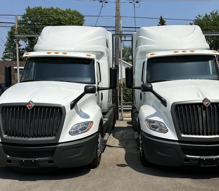 Two white International LT tractors parked side by side in the yard